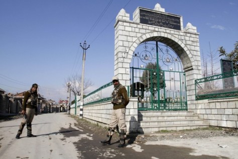 CRPF personnel stand guard at the martyrs' graveyard in Srinagar,preventing entry. The graveyard has a new empty grave, that of Afzal Guru. A similar empty grave waits for Maqbool Bhat, also buried in Tihar jail. Photo credit: Mukhtar Khan/Associated Press